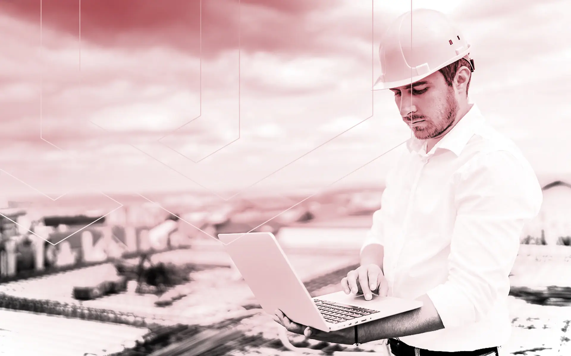 Bauleiter mit Schutzhelm arbeitet auf der Baustelle an einem Laptop