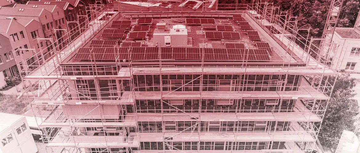 Luftaufnahme des eingerüsteten Holz-Wohngebäudes mit Photovoltaik-Dach im Ellener Hof