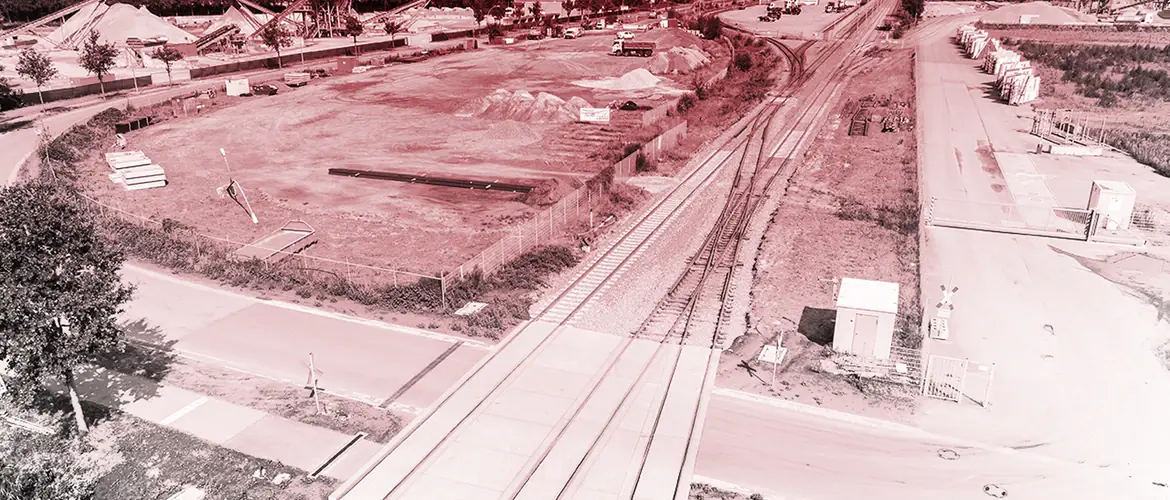 Luftaufnahme des modernisierten Haltepunkts Emlichheim mit neuen Gleisen und Bahnübergang